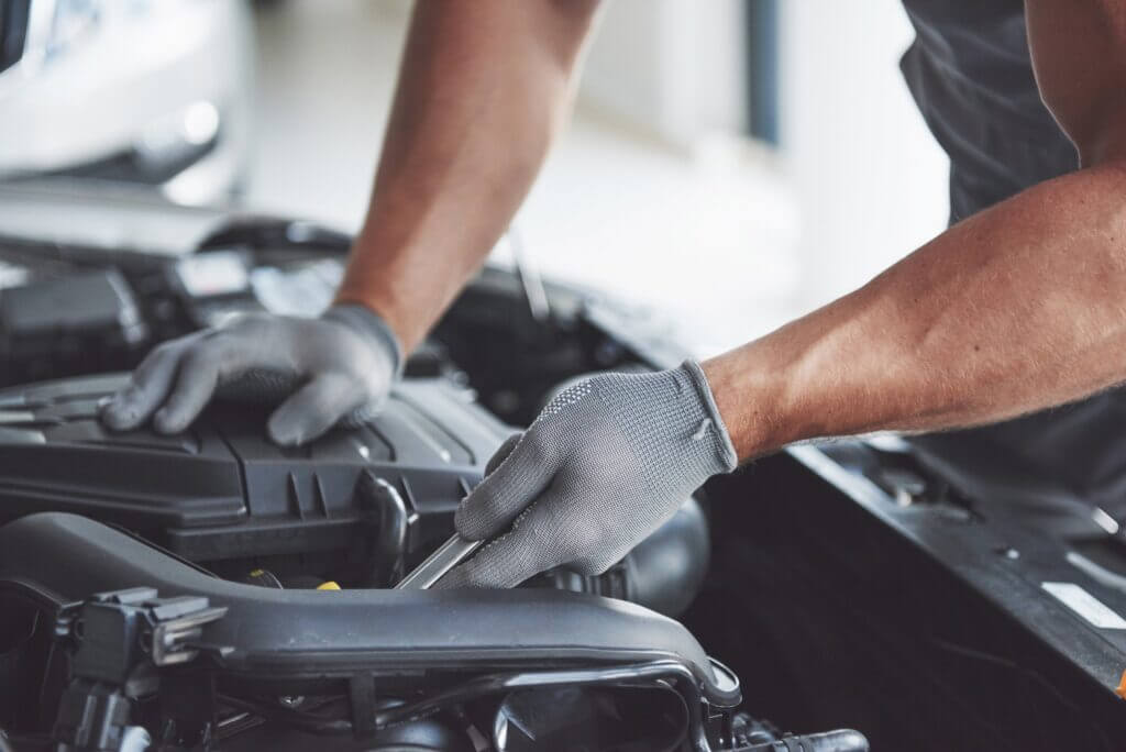 Spring Car Care Tips Newark, NJ | EPR Auto Clinic 2 Mechanic inspecting and working on a car engine in a professional auto repair garage in Newark, NJ