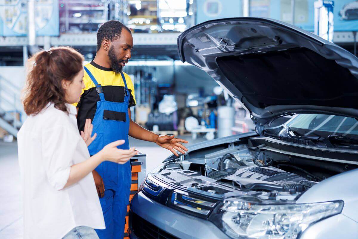 Mechanic showing car engine to customer during vehicle maintenance check at EPR Auto Clinic in Newark NJ
