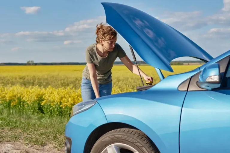 Spring Car Care Tips Newark, NJ | EPR Auto Clinic 1 Woman checking car engine on the side of the road during spring maintenance.