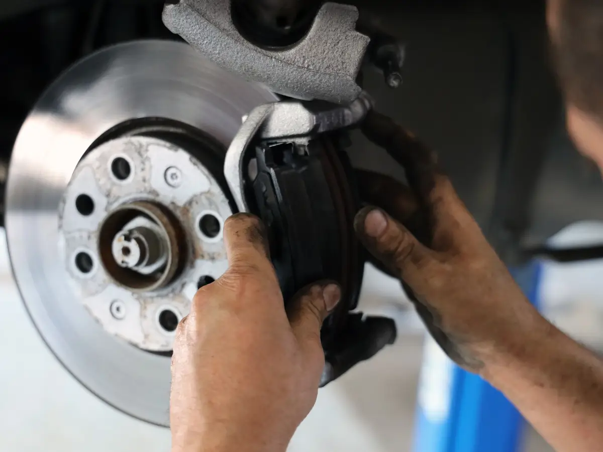 EPR Auto Clinic in Newark, NJ 3 An EPR Auto Clinic technician installing a new, high-quality brake pad into a caliper during a professional brake repair service in Newark for enhanced vehicle safety