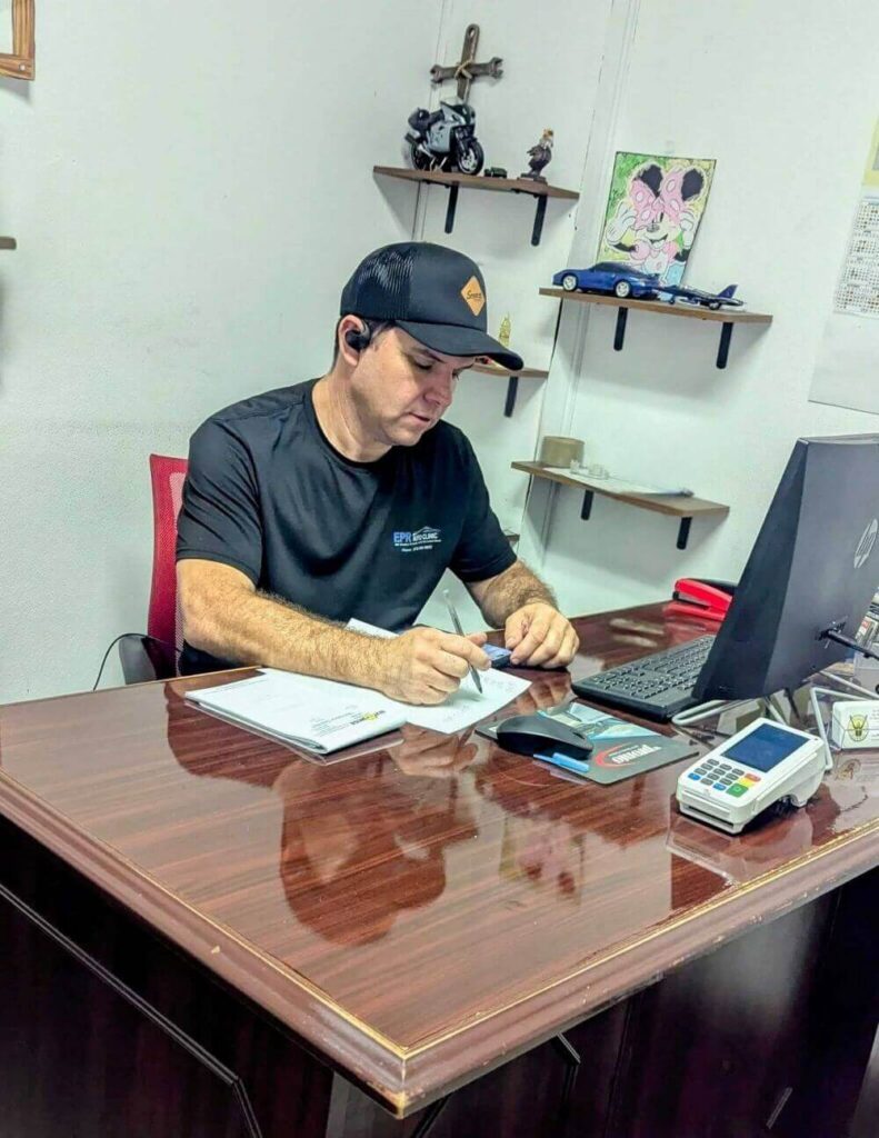 Ednei completing paperwork at the EPR Auto Clinic office in Newark