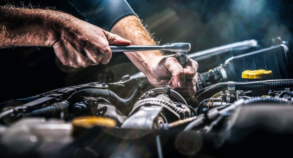Essential Car Maintenance Tips for Winter Safety 4 Close-up of skilled hands using a wrench to work on a car engine at EPR Auto Clinic in Newark, highlighting our expertise in engine repair