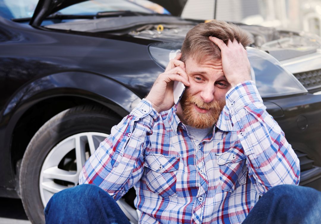 Man frustrated with broken car calling for roadside assistance — auto repair in Newark NJ